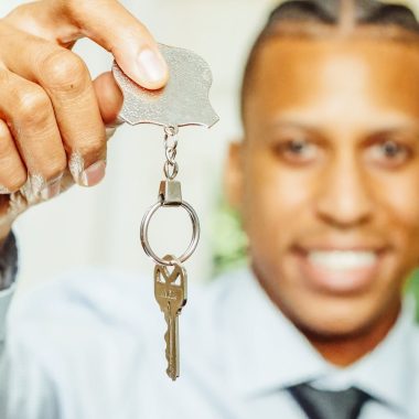 Man in White Dress Shirt Holding a Silver Key