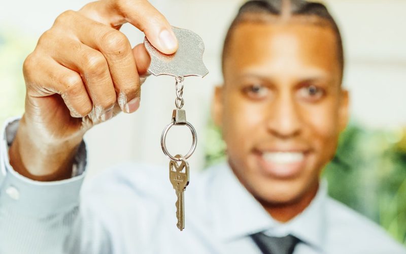 Man in White Dress Shirt Holding a Silver Key