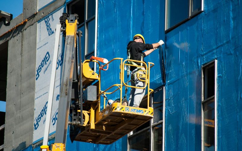 Worker Insulating a Building from the Skylift Basket