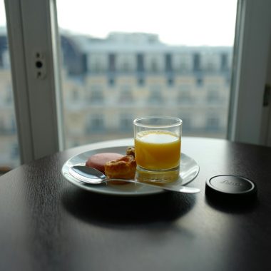 cup filled with yellow liquid beside bread on plate