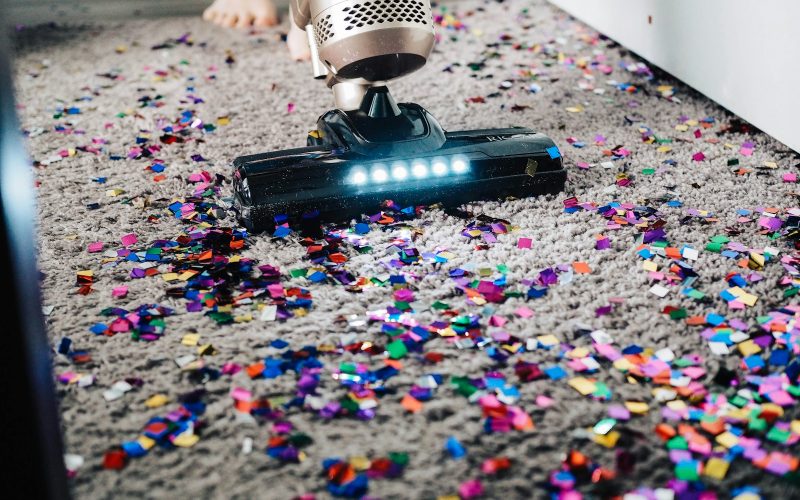 a person using a vacuum to clean a carpet