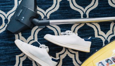 pair of white sneakers beside vacuum cleaner